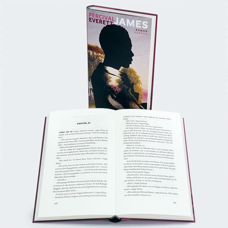 Ein geöffneter Roman von Percival Everett mit dem Titel 'James'. Das Cover zeigt das schwarze Silhouettenprofil eines Menschen vor einem farbigen Hintergrund. Der Text im aufgeschlagenen Buch ist klar lesbar.