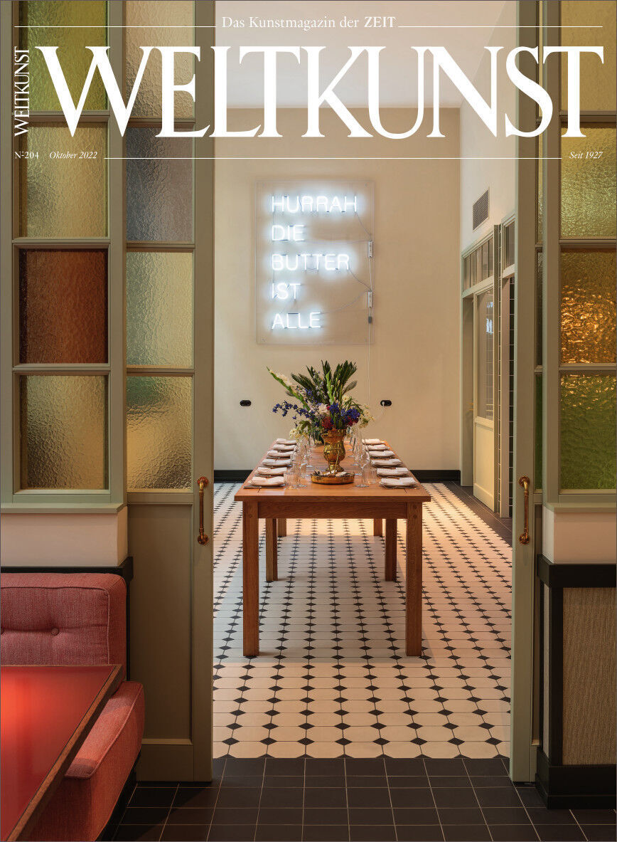 Cover des WELTKUNST Magazins 204/22 Design Spezial. Zu sehen ist ein stilvoll eingerichteter Raum mit einem langen Esstisch, dekoriert mit Blumenarrangements, unter moderner Beleuchtung und Kunstdeko an den Wänden. Der Raum hat eine hauptsächlich beige und braune Farbpalette mit Akzenten in Weiß, Schwarz, Pink und Grün.