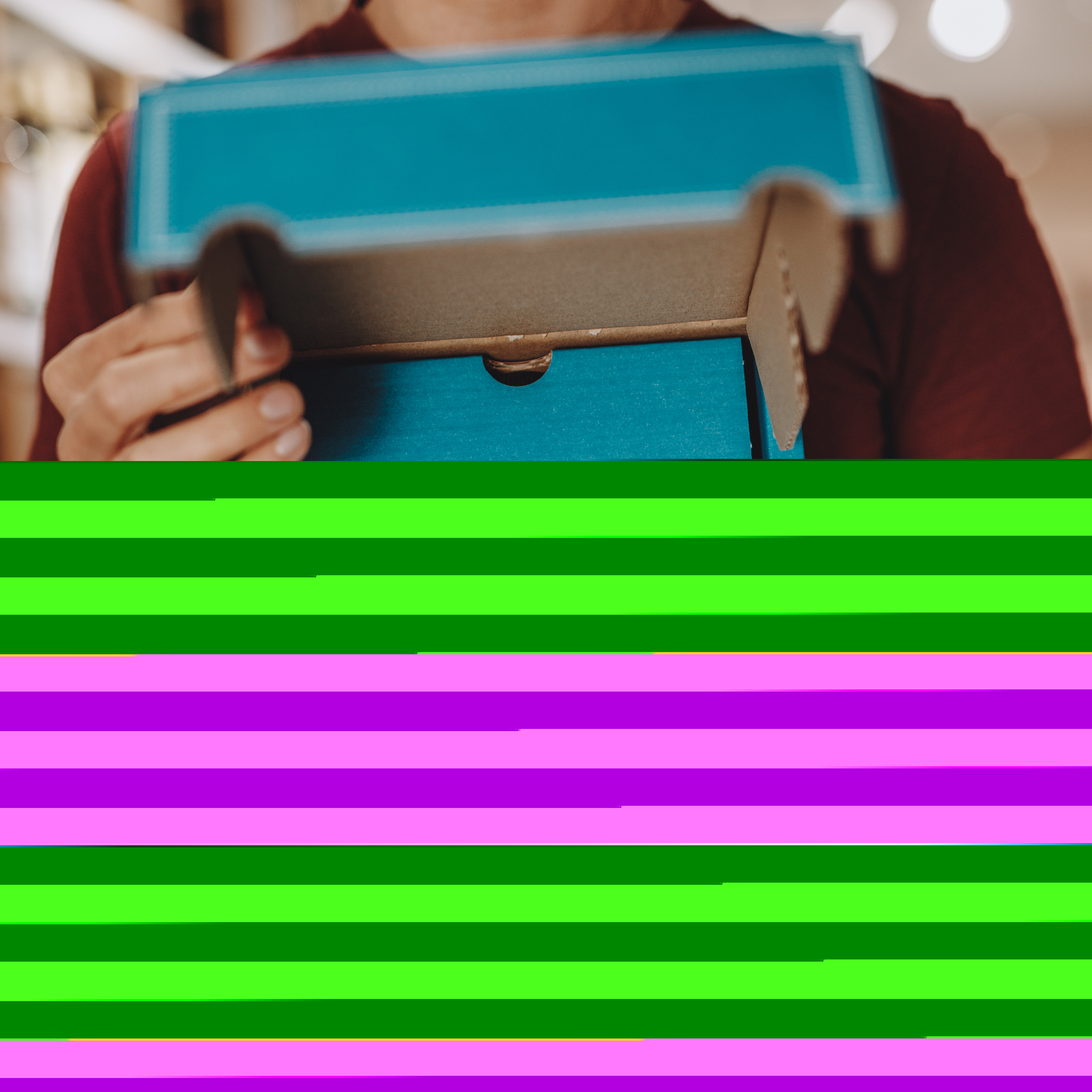 Eine Person hält eine blaue Geschenkbox mit weißem Herzsymbol und der Aufschrift 'Mit Liebe handgemacht' in den Händen. Der Karton ist geöffnet und steht im Vordergrund. Die Szene vermittelt einen hochwertigen, liebevoll verpackten Eindruck, geeignet als Geschenk zu verschiedenen Anlässen.