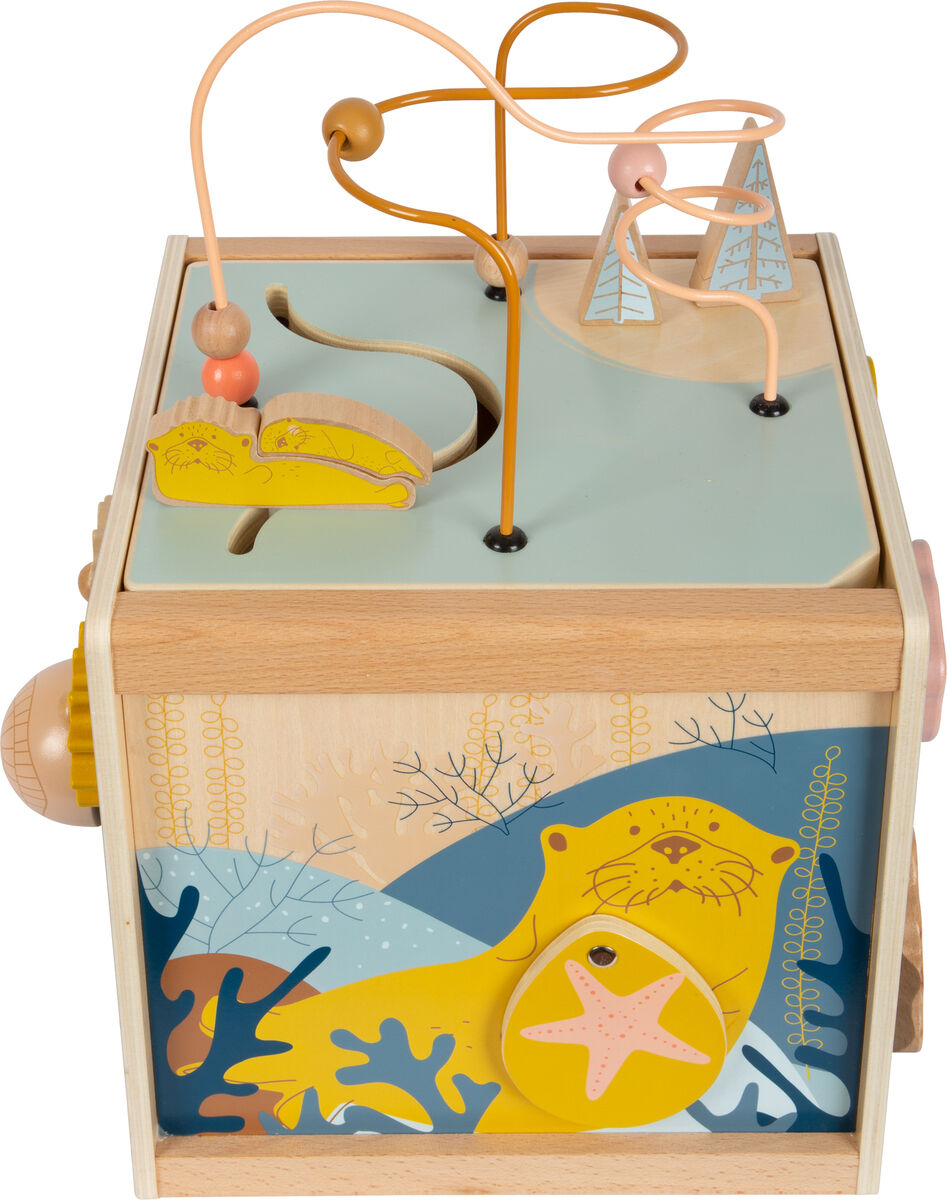 Eine Motorikkiste aus Holz mit dem Titel 'Seaside'. Die Box zeigt ein maritimes Design mit einem Seehund, Seestern und unterseeischen Pflanzen in leuchtenden Farben. Oben befinden sich Drähte mit Holzperlen zur Förderung der Feinmotorik von Kindern.