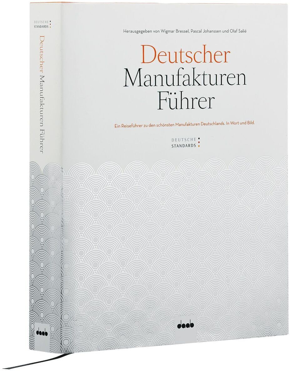 Ein Buch mit dem Titel 'Deutscher Manufakturenführer'. Der Buchumschlag ist überwiegend weiß, mit fein strukturiertem Muster und schwarzem sowie orangem Text darauf.
