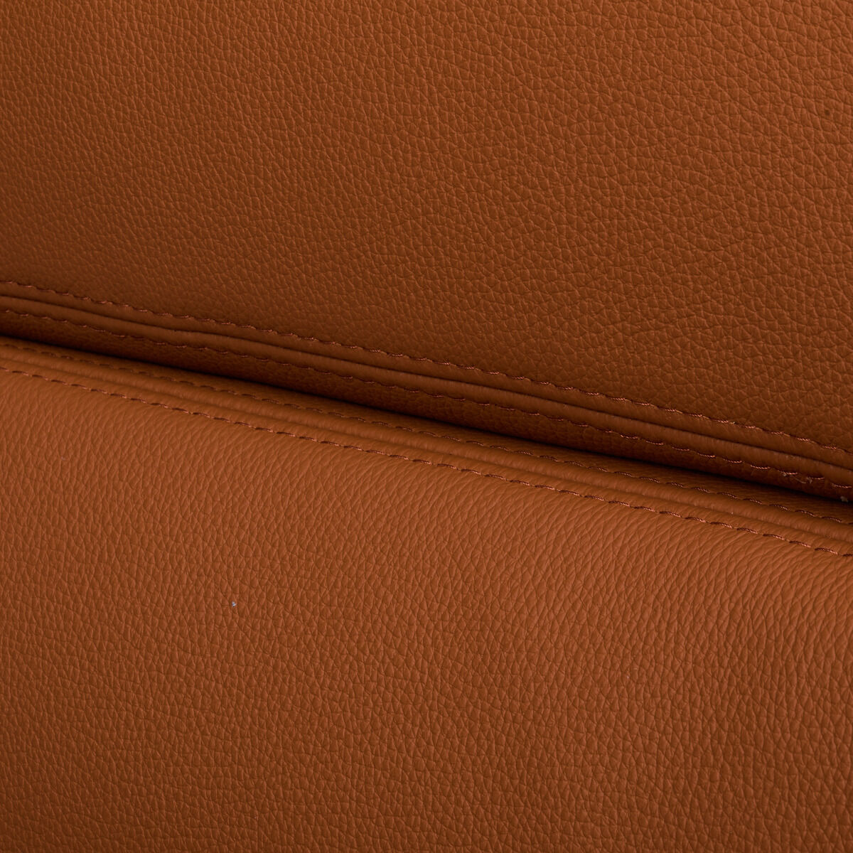 Detailaufnahme von zwei übereinanderliegenden, weich gepolsterten Lederkissen in warmem Cognac-Farbton mit feiner Narbung und sichtbarer, gerader Naht. Das Material wirkt hochwertig, die Verarbeitung präzise und elegant, typisch für Vitra Designmöbel.