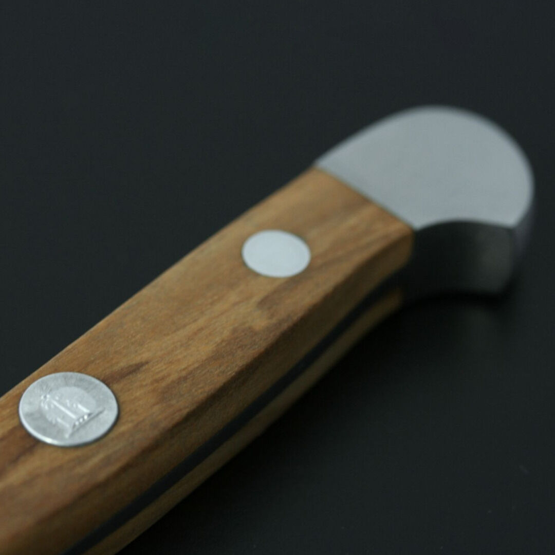 Spickmesser mit einem Griff aus Olivenholz und einer silbernen Stahlklinge auf dunklem Hintergrund.