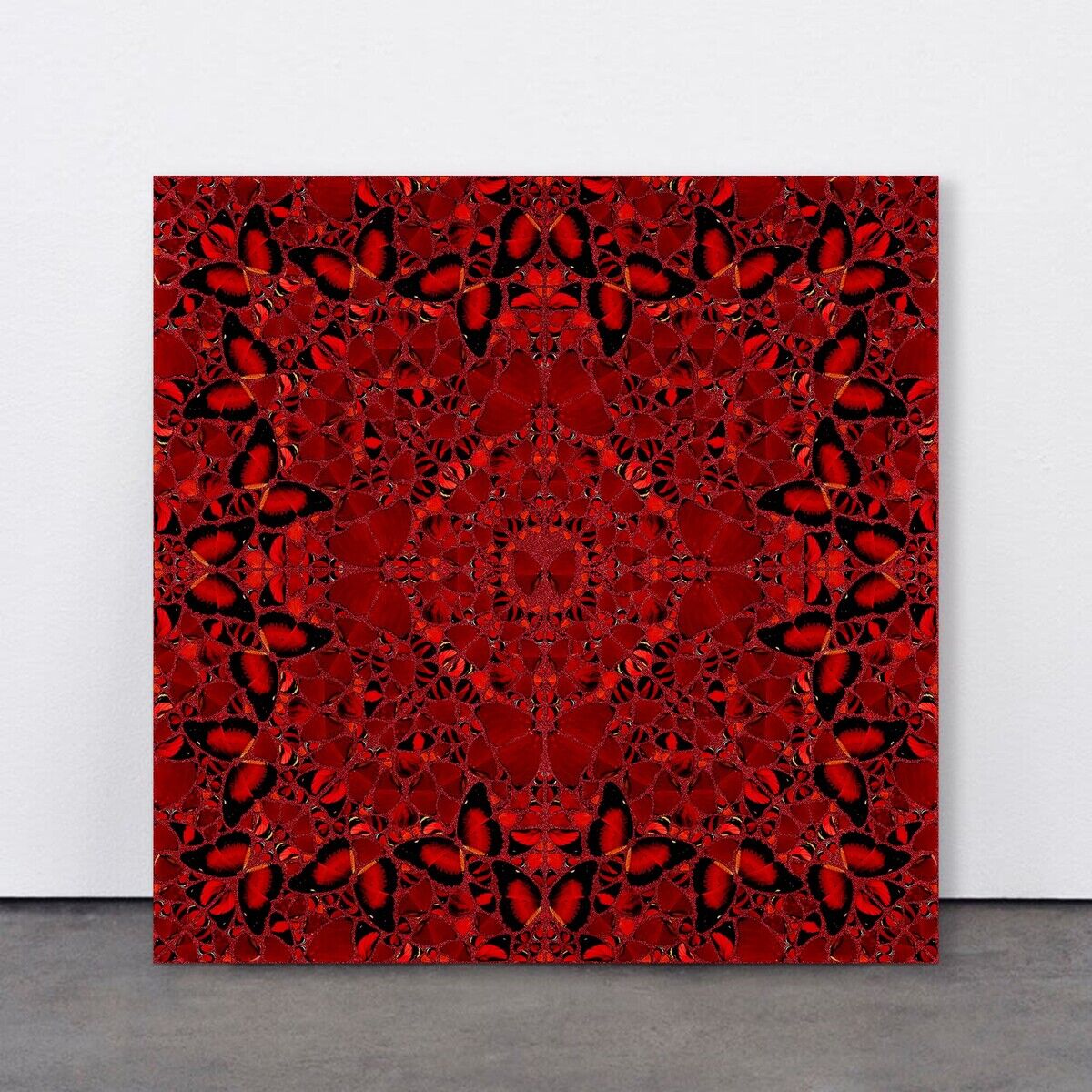 Ein quadratisches Kunstwerk von Damien Hirst mit dem Titel »Nūr Jahān« aus der Serie The Empresses, erschaffen im Jahr 2022. Das Bild zeigt ein komplexes, symmetrisches, mandalaartiges Muster in Rottönen mit Schmetterlingsformen, die auf schwarzem Hintergrund angedeutet sind.