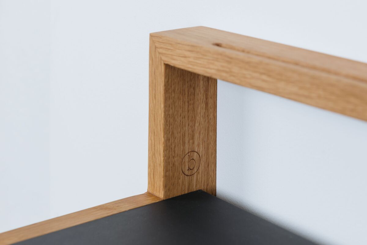 Nahaufnahme eines modernen Ablagebords namens 'buck' in Anthrazit, präsentiert in einem minimalistischen Design aus Holz und Metall, perfekt geeignet für Wohn- oder Arbeitszimmer.