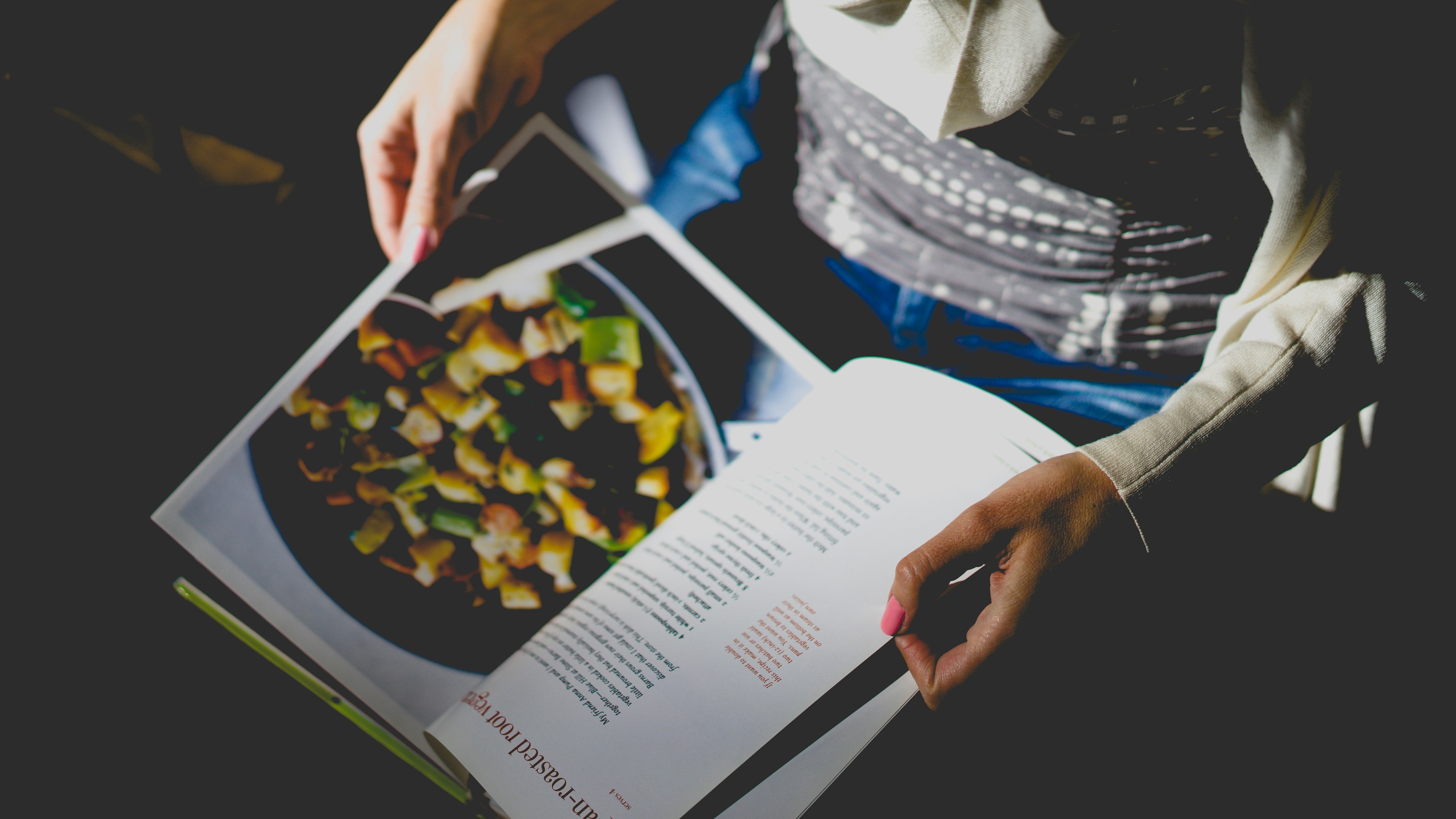 alt="Person blättert in einem Kochbuch – Bild zur Kategorie Kochen & Reisen"