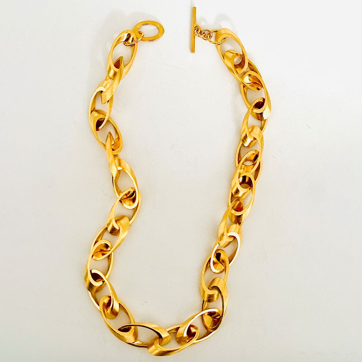 Auf dem Bild ist das ZEIT-Sonderedition Collier "Jackie" der Marke HML Berlin von Horst Max Lebert Lager zu sehen. Die Halskette besteht aus großen, feingoldplattierten Gliedern aus 925er Silber in auffälligem Gelbgold und hochwertiger Verarbeitung, mit einem eleganten Knebelverschluss.