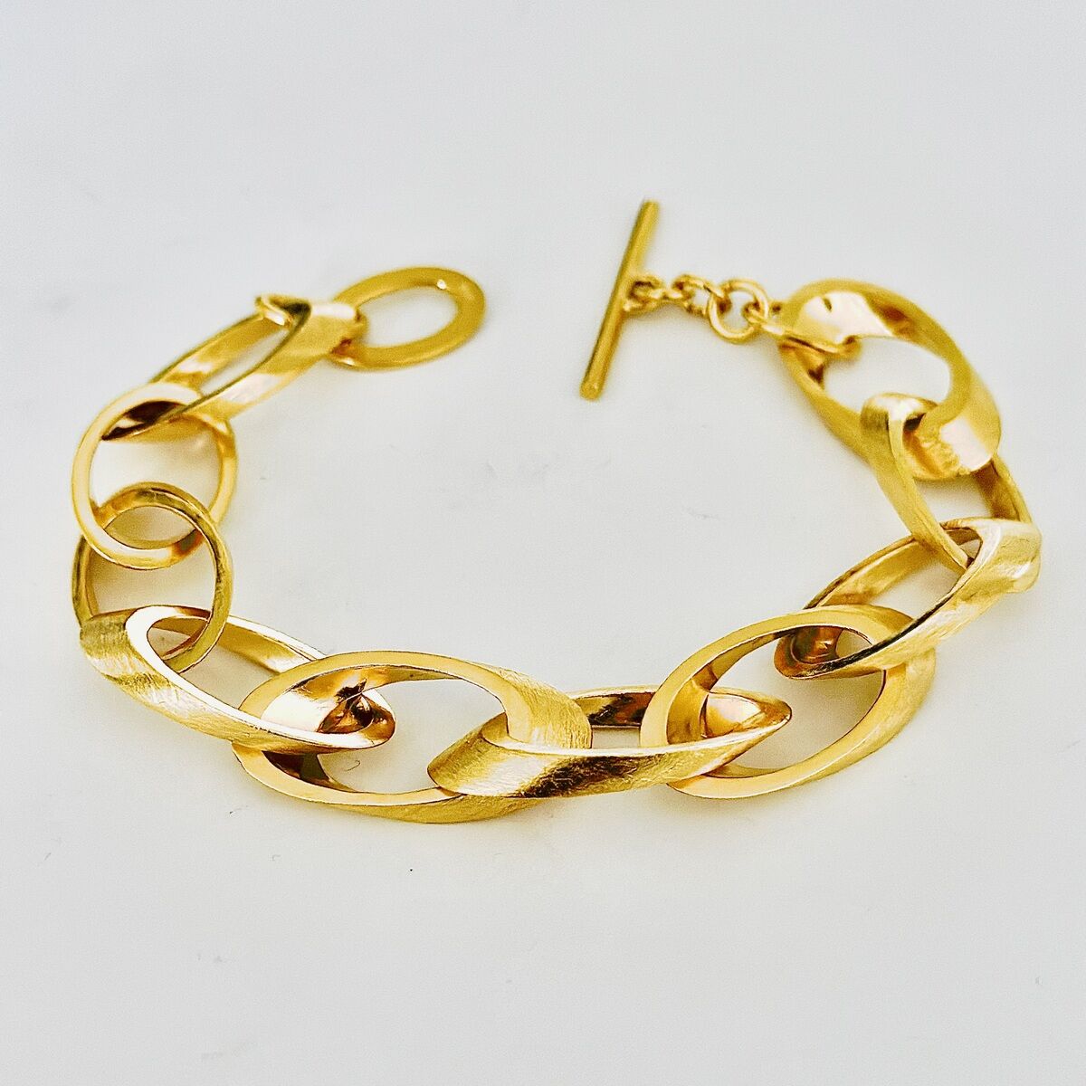 Ein elegantes Armband aus Silber mit einer feingoldplattierten Oberfläche, bestehend aus großen Kettengliedern.