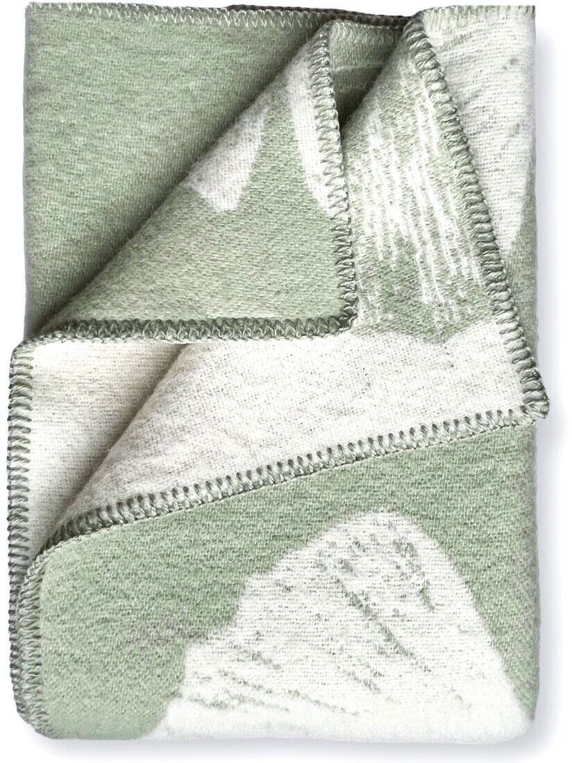 Bild einer gefalteten Decke mit Ginkgo-Muster in den Farben Grün und Creme, detailreich bestickt.