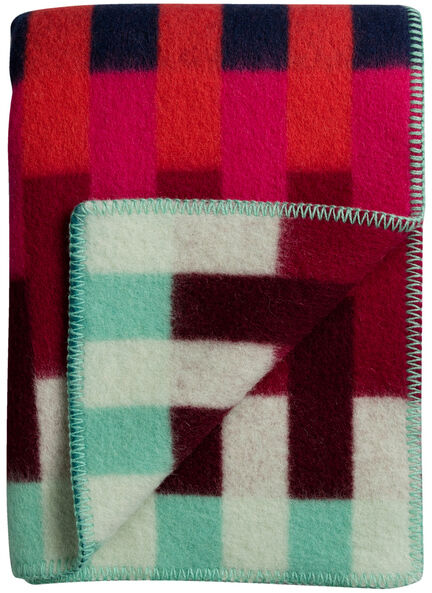 Lammwolldecke »ASMUND Bold« in rotem, blauen, grünen und weißen Farben mit geometrischem Muster, zusammengefaltet sichtbar auf weißem Hintergrund.