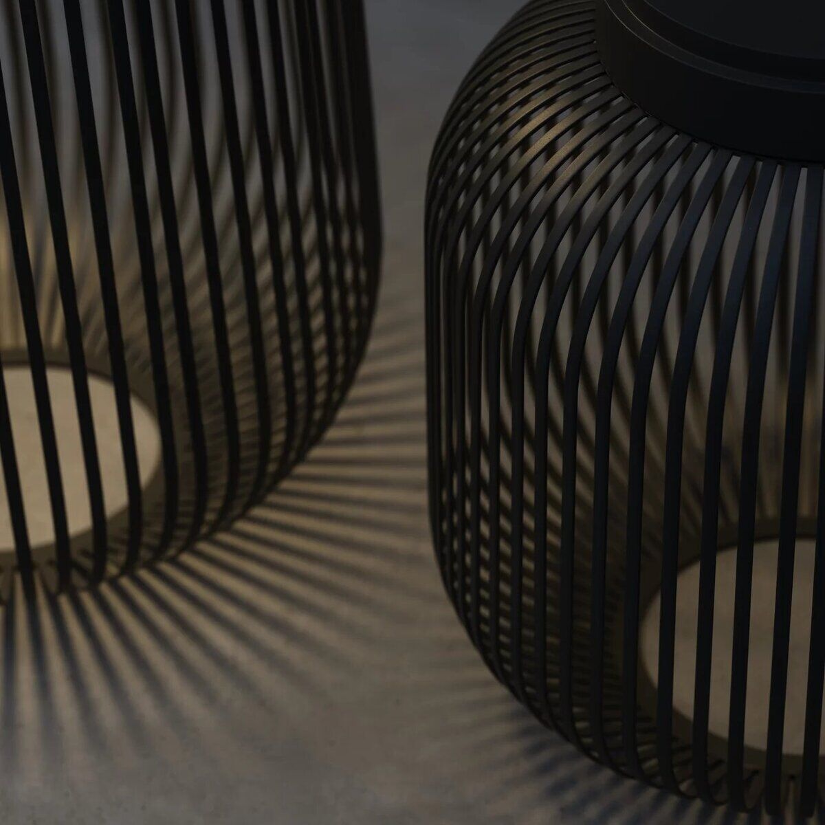 Zwei mobile LED-Leuchten in schwarz mit modernem, stilvollem Design. Die Lampen werfen Schattenmuster auf den Boden, ideal für Innenraumbeleuchtung und Wohnaccessoires.