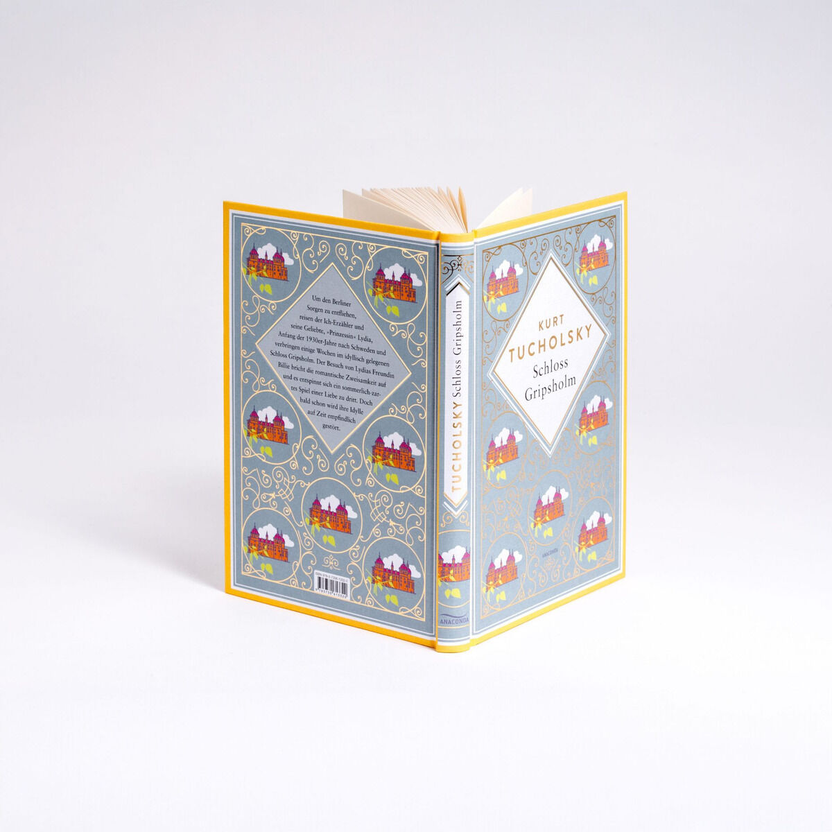 Ein aufgeschlagenes Buch von Kurt Tucholsky mit dem Titel 'Schloss Gripsholm. Eine Sommer Schmuck' in hellblauer und gelber Gestaltung mit dekorativem Muster und einem Schlossmotiv auf dem Cover.