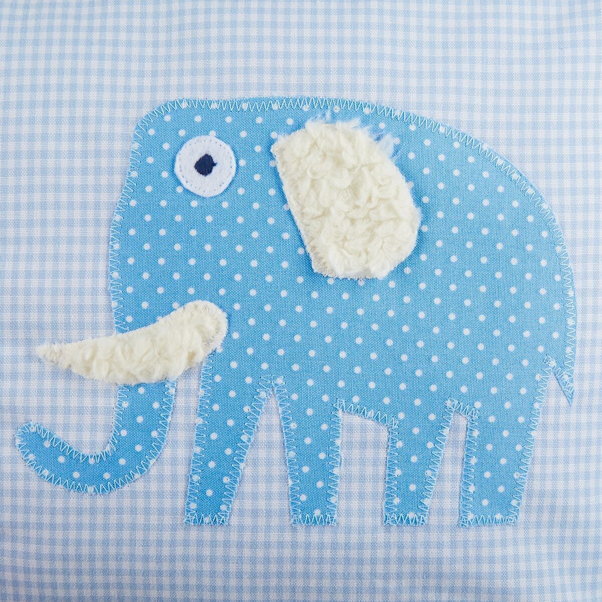 Hellblaues Kissen mit einem applizierten Elefantenmotiv in Blau mit weißen Punkten. Der Elefant hat ein weißes Auge und ein weißes Ohr.