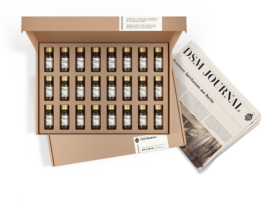 Eine geöffnete Verkostungsbox mit verschiedenen kleinen Flaschen Spirituosen-Spezialitäten und einem Faltblatt, auf dem 'DSM Journal' steht. Die Box und das Blatt befinden sich auf einem weißen Hintergrund.