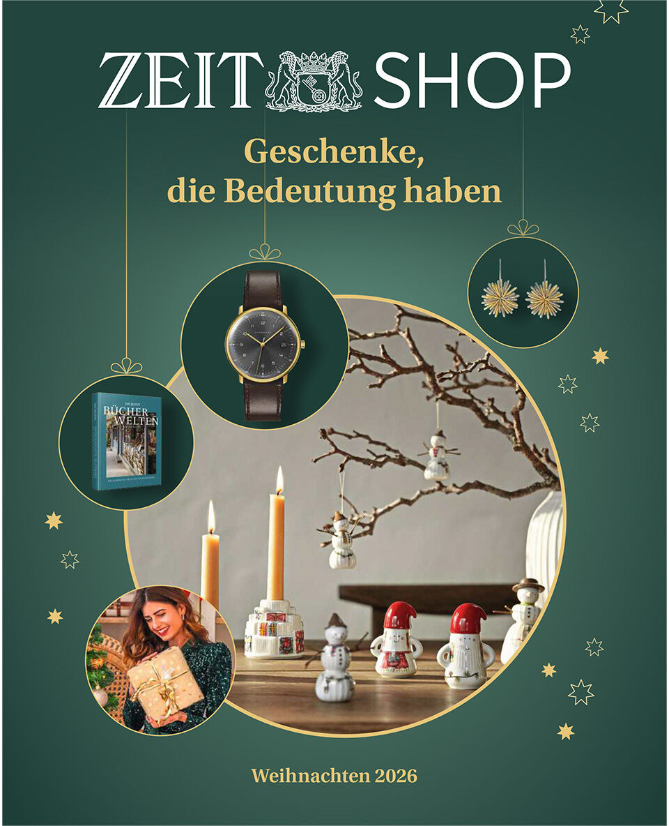 Dunkelgrünes Cover des Katalogs „ZEIT SHOP – Geschenke, die Bedeutung haben“, Weihnachten 2026. Goldene Sterne und Kreise rahmen eine Uhr, ein Buch und eine Frau mit Geschenk. Zentral steht ein festlich dekorierter Tisch mit Kerzen, Wichtelfiguren und blühendem Zweig vor rundem Spiegel.