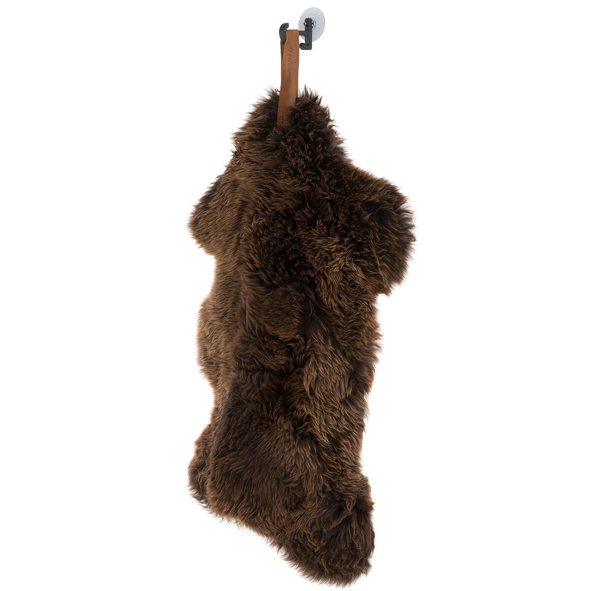 Ein braunes Schafsfell mit einer Lederschlaufe hängt an einem Haken vor weißem Hintergrund. Das Fell wirkt weich, flauschig und naturbelassen. Perfekt als Dekoration oder gemütliches Wohnaccessoire.