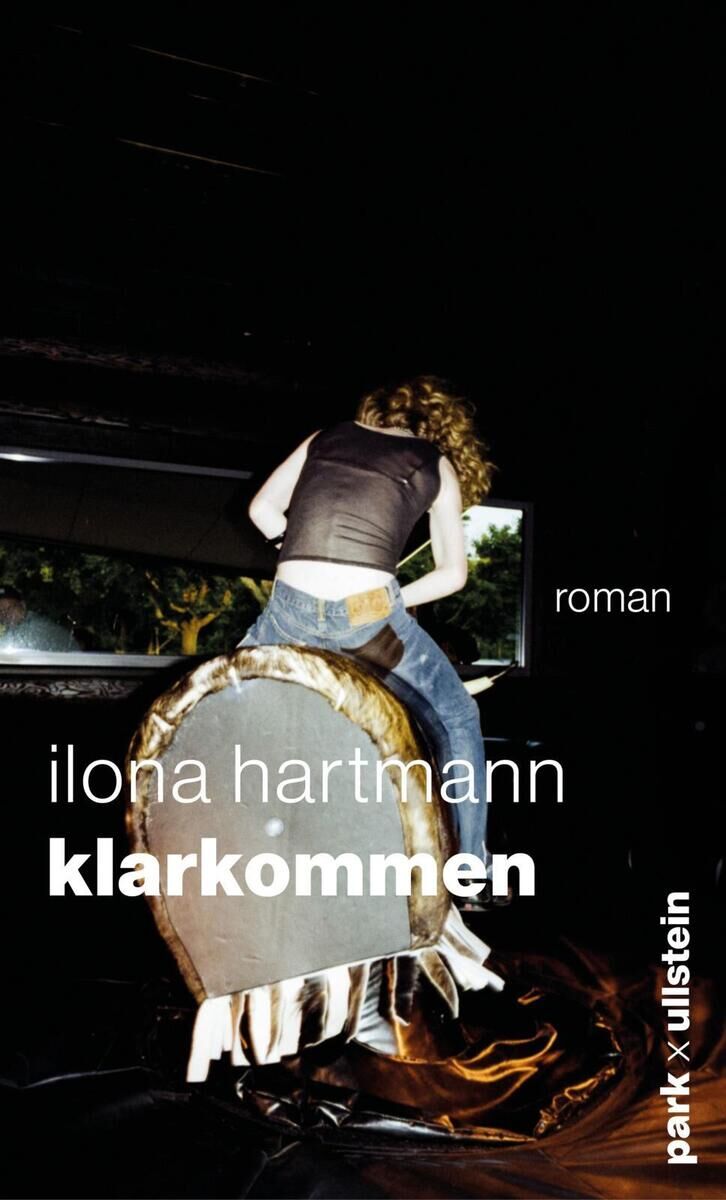 Das Cover des Buches 'Klarkommen' von Ilona Hartmann zeigt eine Person, die auf einem mechanischen Bullen reitet. Der Hintergrund ist dunkel, mit einem leicht beleuchteten Bereich. Der Titel des Buches und der Name der Autorin sind in weißer und grauer Schrift abgebildet.