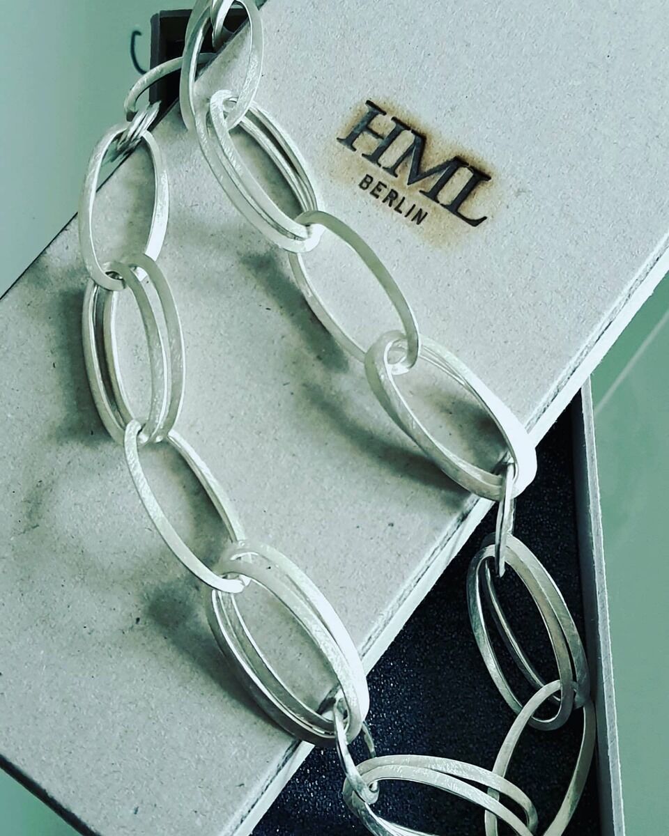 Eine elegante, handgefertigte Silberkette der Marke HML-Collier »GRACE« liegt auf einer schwarzen und weißen Verpackung mit dem Logo 'HML Berlin'.