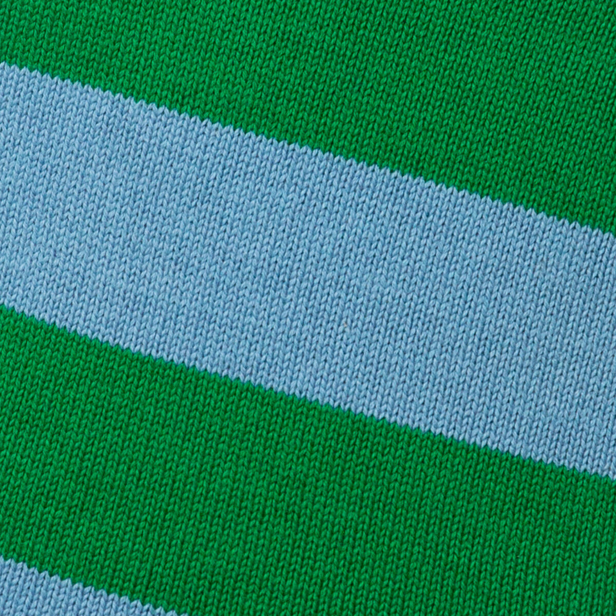 Detailaufnahme eines gestrickten Stoffbezugs der Wärmflasche gestreift Blau von SUITE702. Die Oberfläche zeigt breite, diagonale Streifen in Himmelblau und Grün. Die feine Strickstruktur aus Baumwolle ist deutlich sichtbar. Keine weiteren Objekte sind zu sehen.