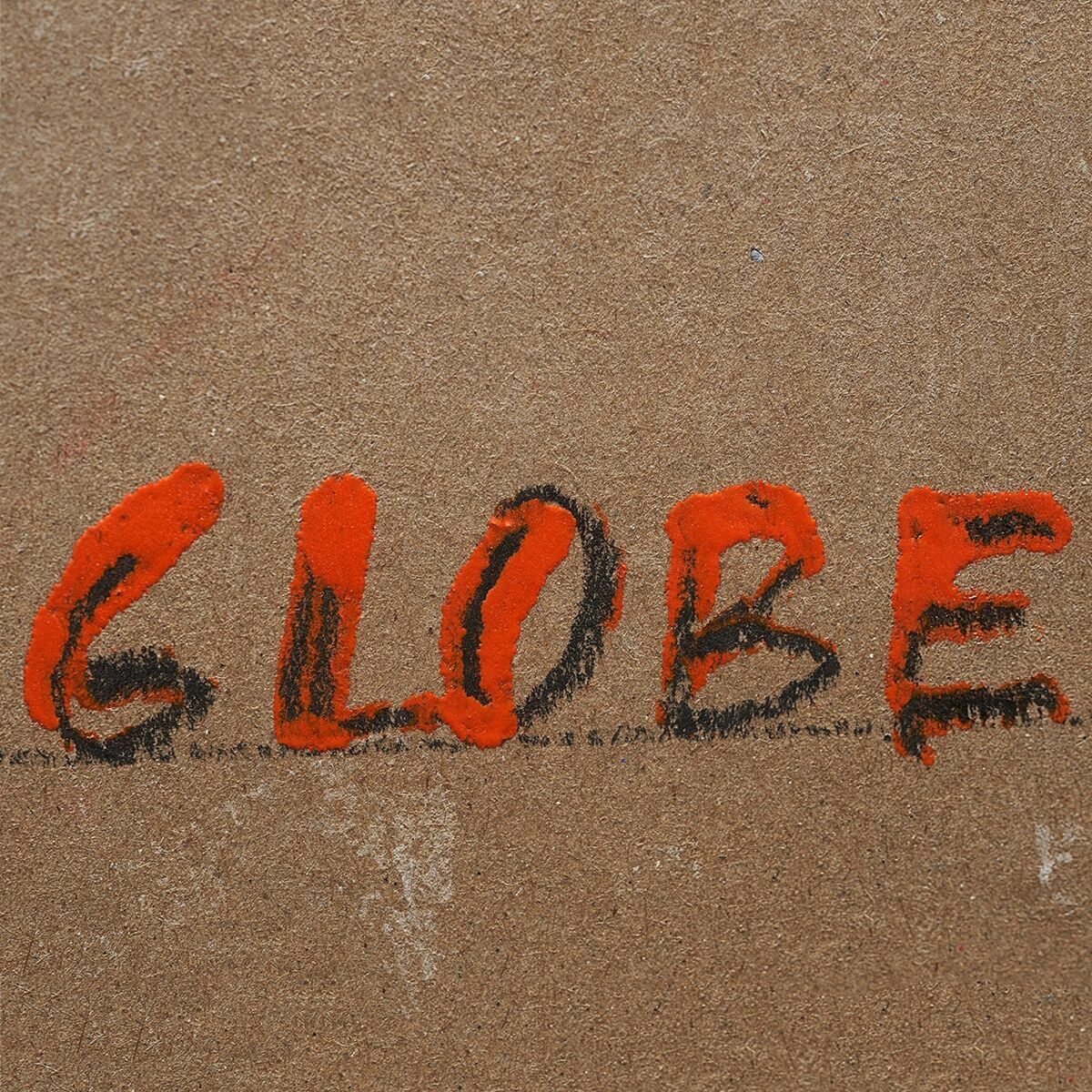 Nahaufnahme eines Kunstwerks von Christo namens 'Wrapped Globe'. Der Hintergrund ist braun mit dem Wort 'GLOBE' in schwarzen und roten Buchstaben gezeichnet.