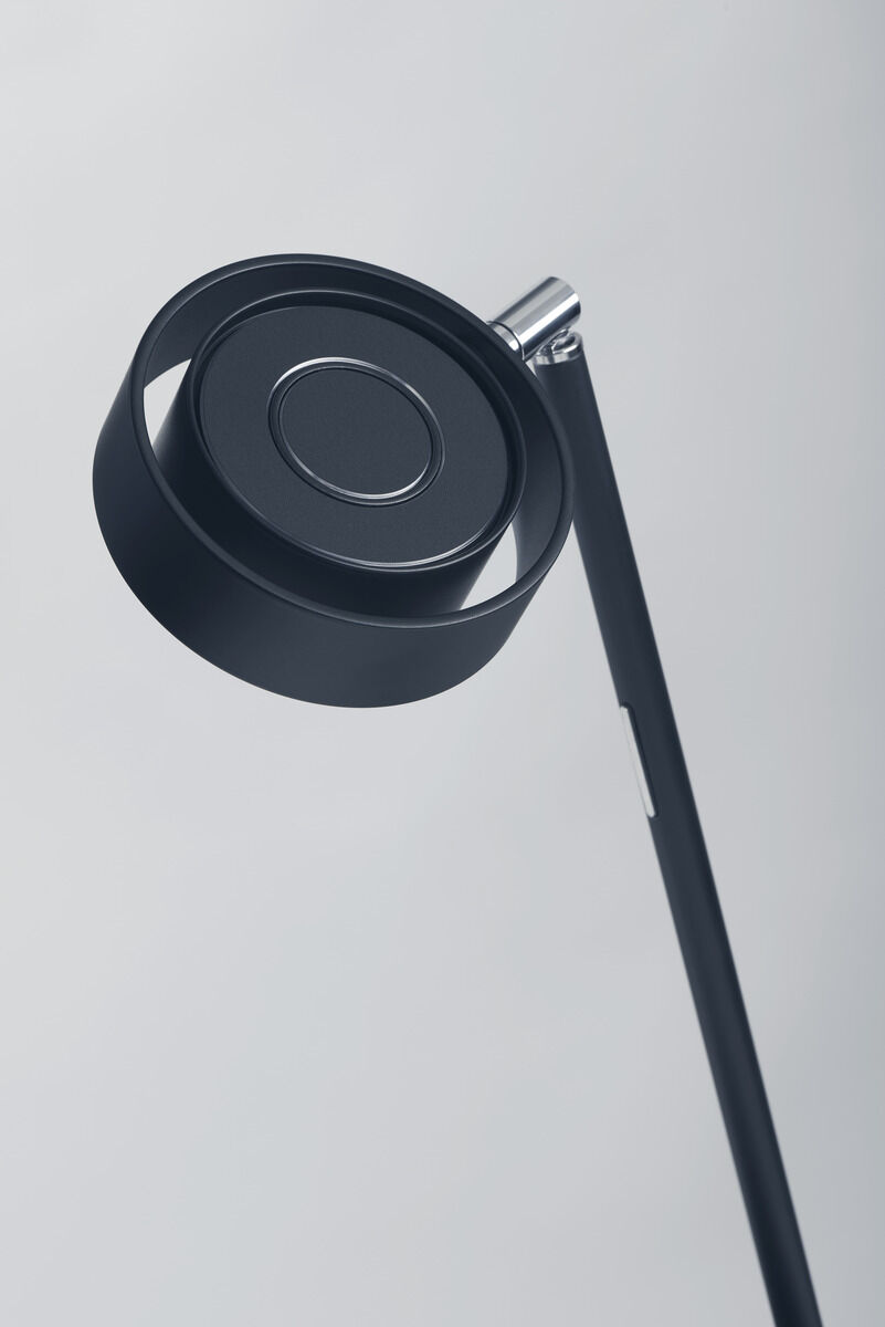 Schwarze Tischleuchte ZEIT-Jubiläumsedition »Pure« mit modernem, minimalistischem Design und schwenkbarem Kopf vor grauem Hintergrund.