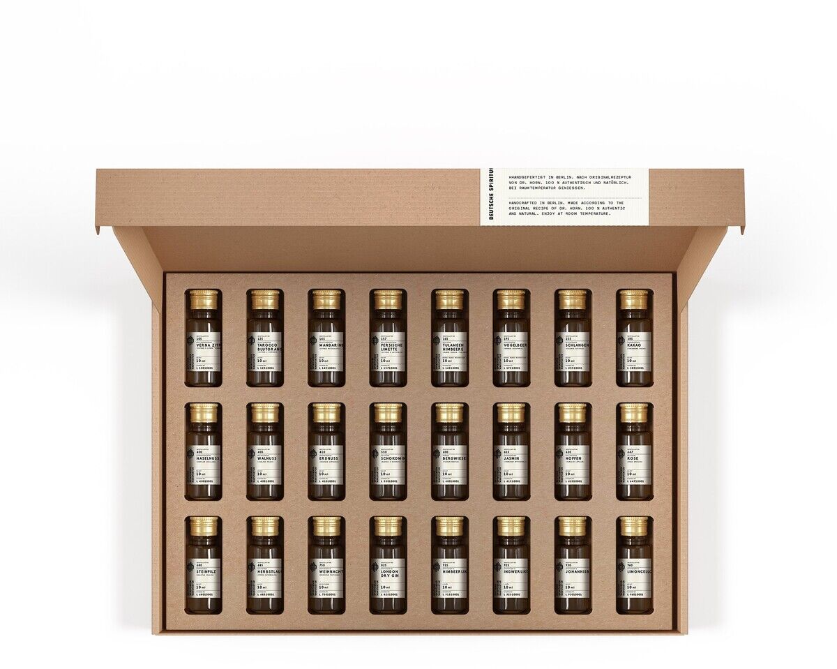 Eine geöffnete, braune Geschenkbox mit 24 kleinen Flaschen gefüllt mit verschiedenen Spirituosen-Spezialitäten. Jede Flasche hat einen goldfarbenen Verschluss und ein weißes Etikett.