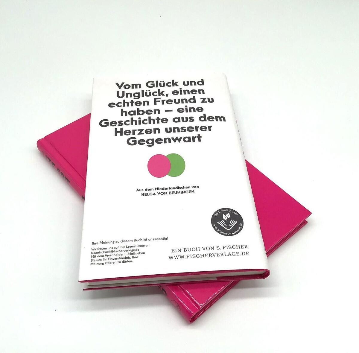 Das Bild zeigt ein Buch mit dem Titel 'Spit, L: Der ehrliche Finder' von Helga von Beuningen, veröffentlicht vom Fischer Verlag. Das Buch hat ein weißes Cover mit schwarzem Text und zwei bunten Kreisen in Pink und Grün. Daneben liegt ein pinkes Buch. Der Hintergrund ist weiß.