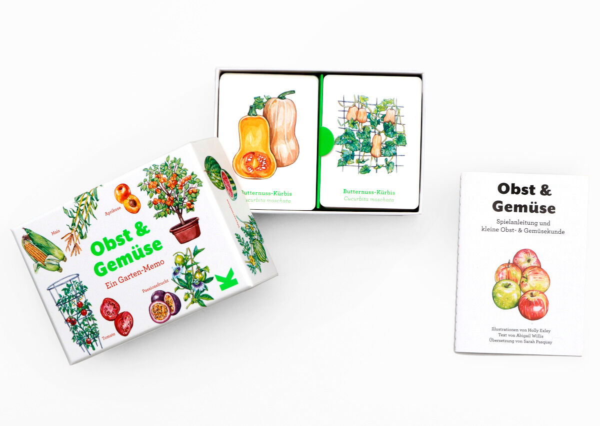 Das Bild zeigt das Memo-Spiel 'Obst und Gemüse'. Es besteht aus Karten mit Illustrationen von verschiedenen Obst- und Gemüsesorten in einer weißen Schachtel. Auf der Schachtel sind bunte Bilder von Früchten und Gemüse zu sehen. Daneben liegt ein Heft mit dem Titel 'Obst & Gemüse'.