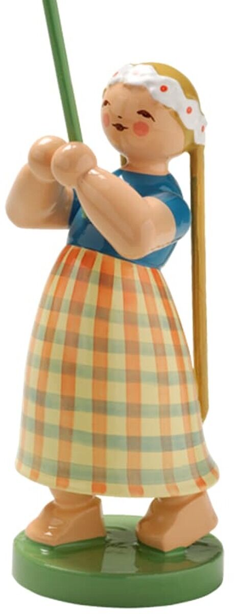 Freigestellte handbemalte Holzfigur »Mädchen mit Margerite« von Wendt & Kühn. Das Mädchen im blau-orange-grün karierten Kleid und weißen Kopftuch hält einen langen grünen Stiel mit großer weißer Margerite und gelber Mitte. Es steht auf einem runden grünen Sockel vor weißem Hintergrund.