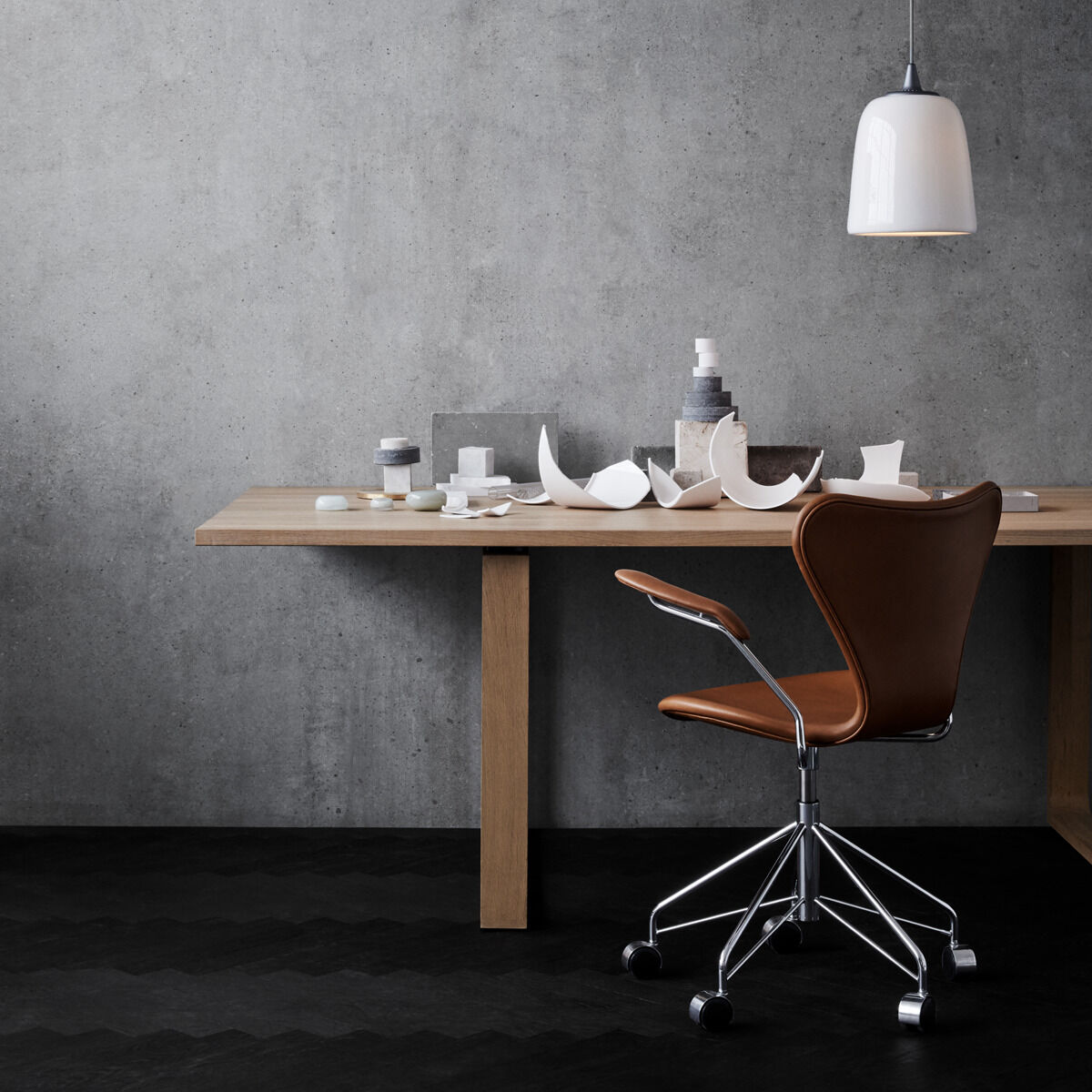 Moderner, ergonomischer Bürostuhl »Series 7™« vor einem minimalistischen Holztisch mit Schreibtischutensilien. Betont die stilvolle und funktionale Arbeitsplatzeinrichtung.