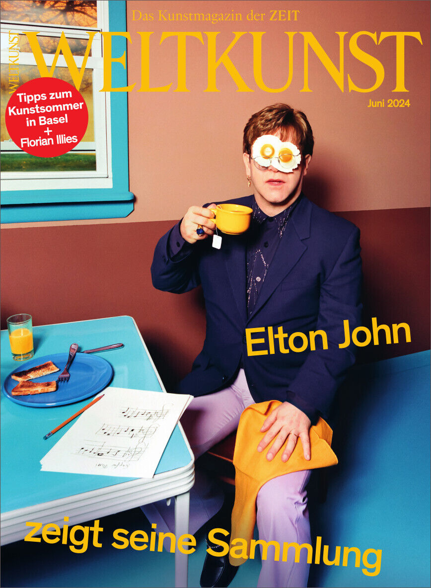 Das Titelbild des Kunstmagazins WELTKUNST zeigt Elton John in einem lilafarbenen Anzug mit einer Tasse in der Hand. Der Hintergrund ist hauptsächlich blau, mit gelben Akzenten im Titel und Text. Auf einem Tisch neben ihm sind ein Frühstücksteller und eine Zeitschrift zu sehen. Das Erscheinungsdatum ist Juni 2024.
