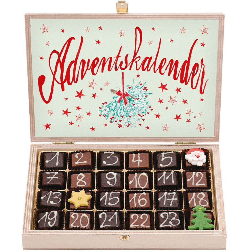 Offene Holzbox mit 24 handgemachten Schokoladentrüffeln von Gmeiner, nummeriert als Adventskalender. Im Deckel steht groß "Adventskalender" mit Sternenmuster und mistelähnlichem Zweig. Zwei Pralinen sind festlich dekoriert, eine als Stern, eine als Tannenbaum.