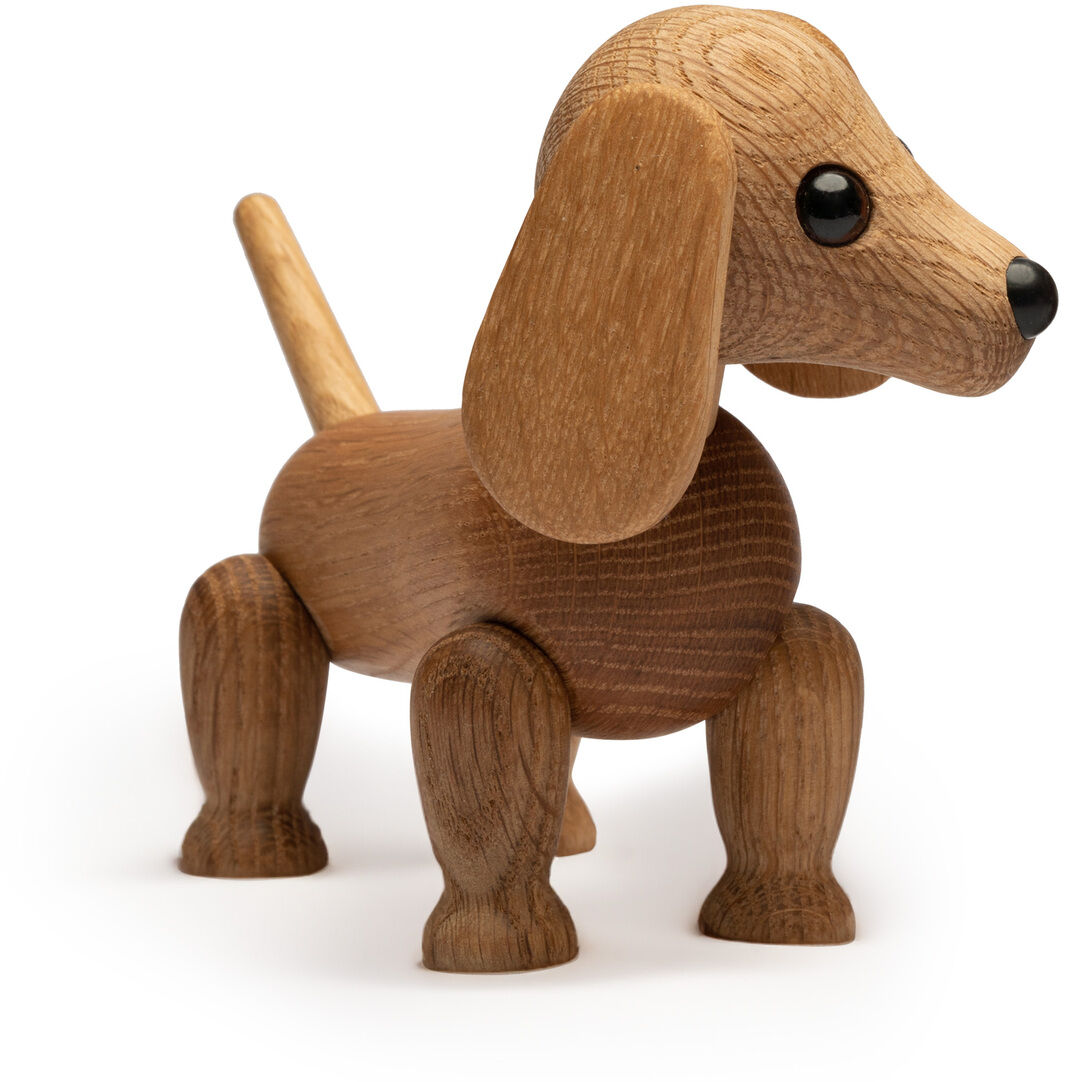 Die Abbildung zeigt die Holzfigur »Dackel Amigo« von Spring Copenhagen. Der Dackel ist detailliert aus braunem Holz gefertigt, hat große schwarze Augen und bewegliche Beine. Das Design ist freundlich und modern, ideal als dekoratives Objekt für Designliebhaber.