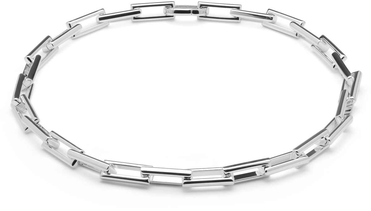 Abgebildet ist ein elegantes, silberfarbenes Collier der Linie »Traverse« mit einer Länge von 42 cm. Die Halskette besteht aus rechteckigen, glänzenden Gliedern und liegt kreisförmig auf einem weißen Hintergrund. Das schlichte und stilvolle Design eignet sich als Schmuckstück für verschiedene festliche Anlässe.