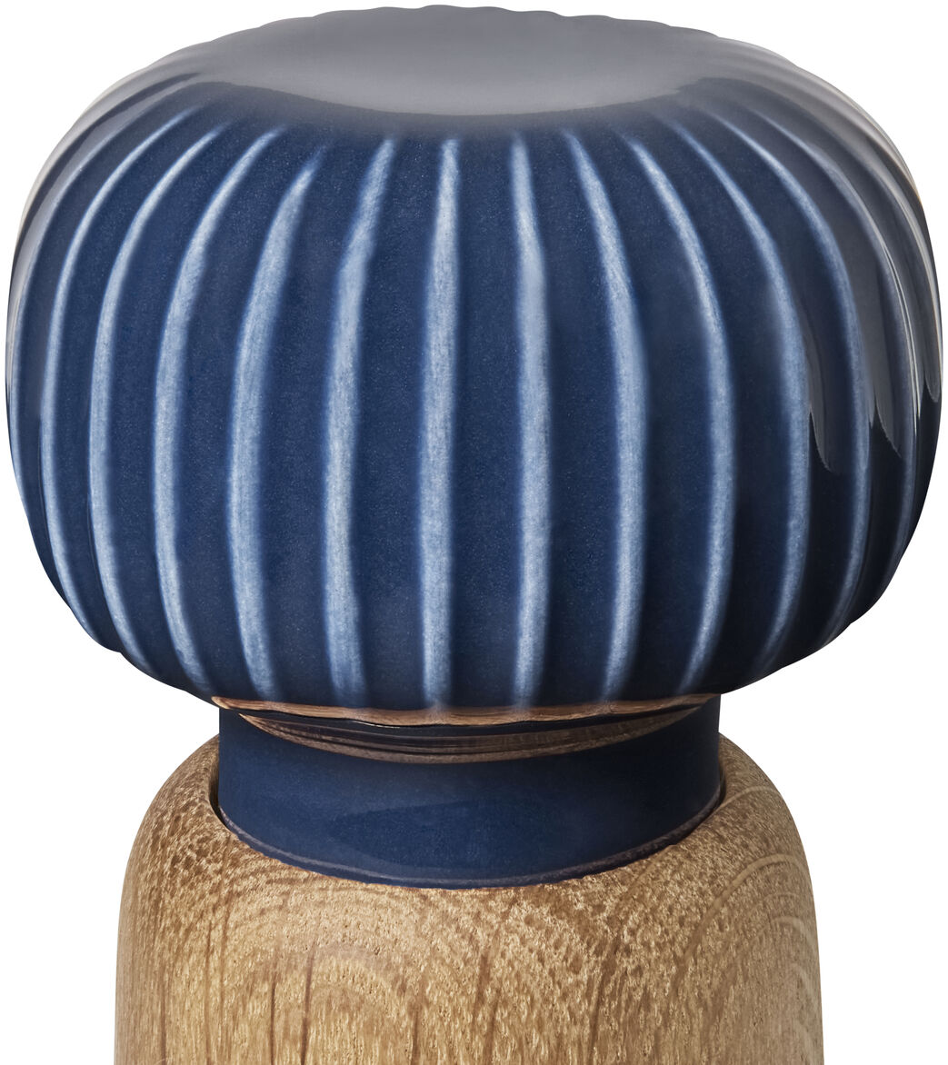 Die Abbildung zeigt eine stilvolle Gewürzmühle der Serie Hammershøi mit geriffelter, blauer Keramikkappe und einem Körper aus hellem Holz, aufgenommen vor weißem Hintergrund.