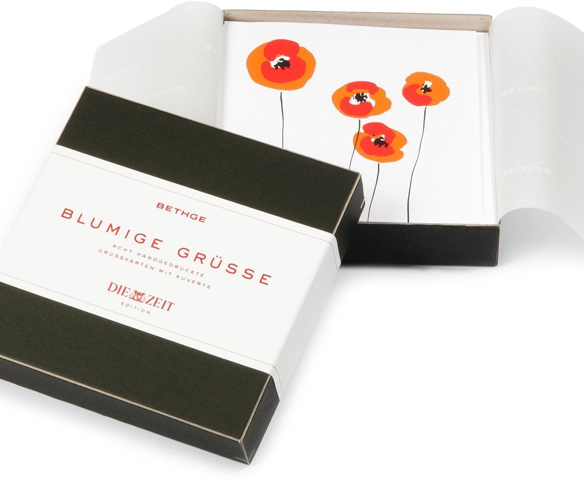 Ein 8-teiliges Grußkarten-Set »Blumige Grüße« in einer Box, mit floralen Motiven von roten und orangefarbenen Blumen auf weißen Karten.