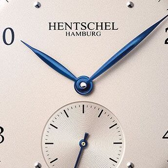 Detailansicht des cremeweißen Zifferblatts der Hentschel Hamburg Jubiläumsuhr ZEIT-Chronometer »H2 Hamburg« mit blauen flammengebläuten Zeigern und kleiner silberner Sekunde, eleganten Applikationen und fein gearbeiteter Typografie.