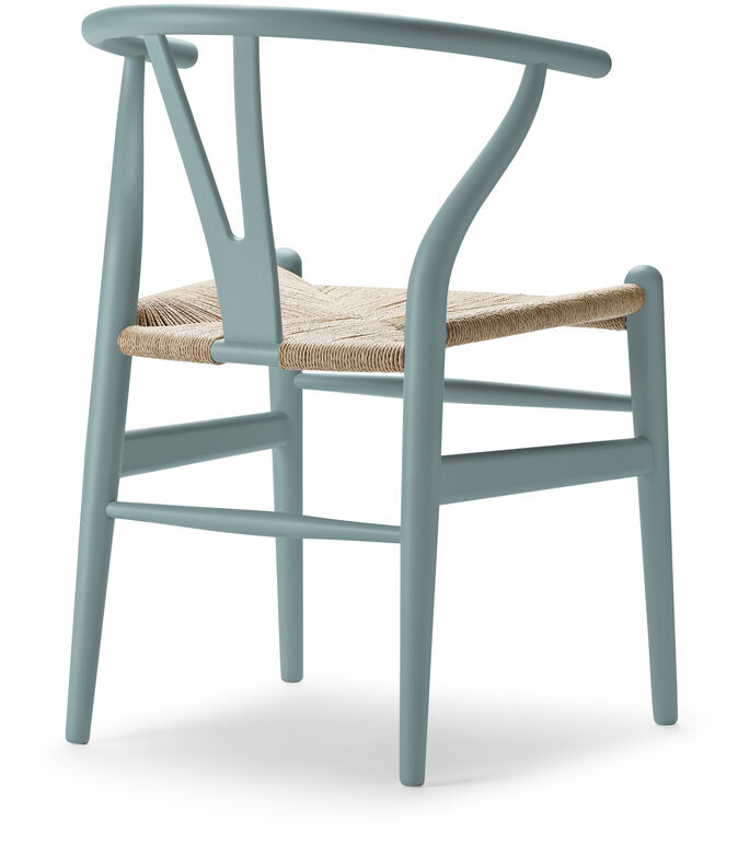 Der Sonderedition „Stuhl CH24 Soft“ von Carl Hansen zeigt einen skandinavischen Designstuhl mit blauer Rückenlehne und Sitzfläche aus Naturmaterial. Ideal für modern eingerichtete Wohnzimmer oder Esszimmer.