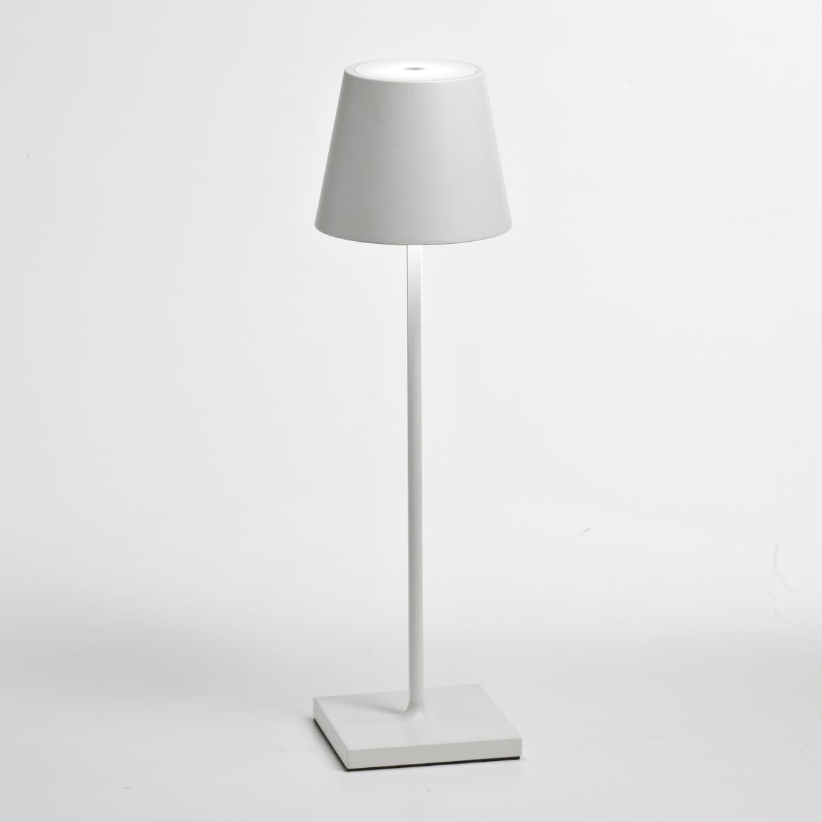 Eine moderne, weiße LED-Tischlampe »Poldina Pro« mit schlichtem, minimalistischen Design. Die Lampe hat einen quadratischen Fuß, einen schlanken Stiel und einen konischen Lampenschirm. Perfekt für den Einsatz auf Schreib- oder Nachttischen.