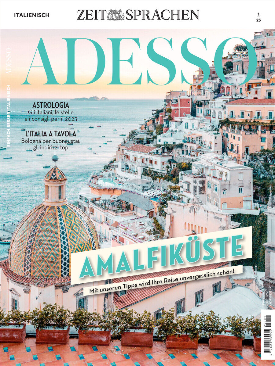 Ein Reisemagazin mit dem Titel 'Adesso' zeigt eine malerische Ansicht der Amalfiküste in Italien mit pastellfarbenen Gebäuden an einem Berghang und einer Kuppel im Vordergrund.