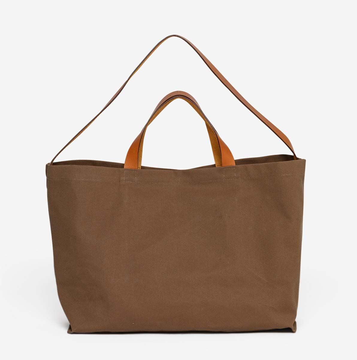 Eine braune Jubiläums-Markttasche mit Lederhenkeln vor einem weißen Hintergrund. Die Tasche hat ein schlichtes und modernes Design und eignet sich hervorragend für Einkäufe und den Besuch auf dem Markt.
