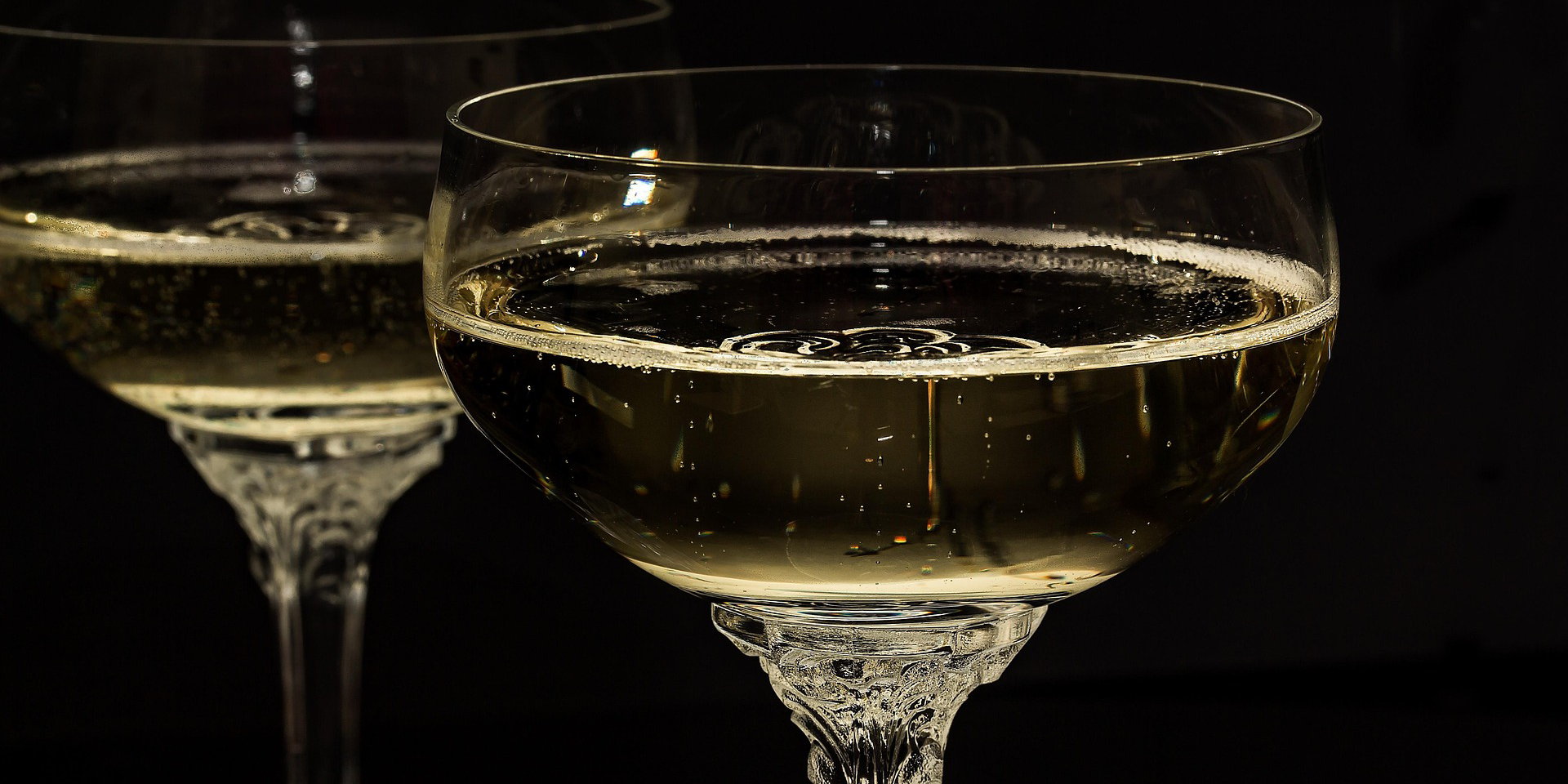 Zwei Sektgläser mit sprudelndem Crémant, in einer eleganten Form mit einem klaren, glitzernden Getränk.