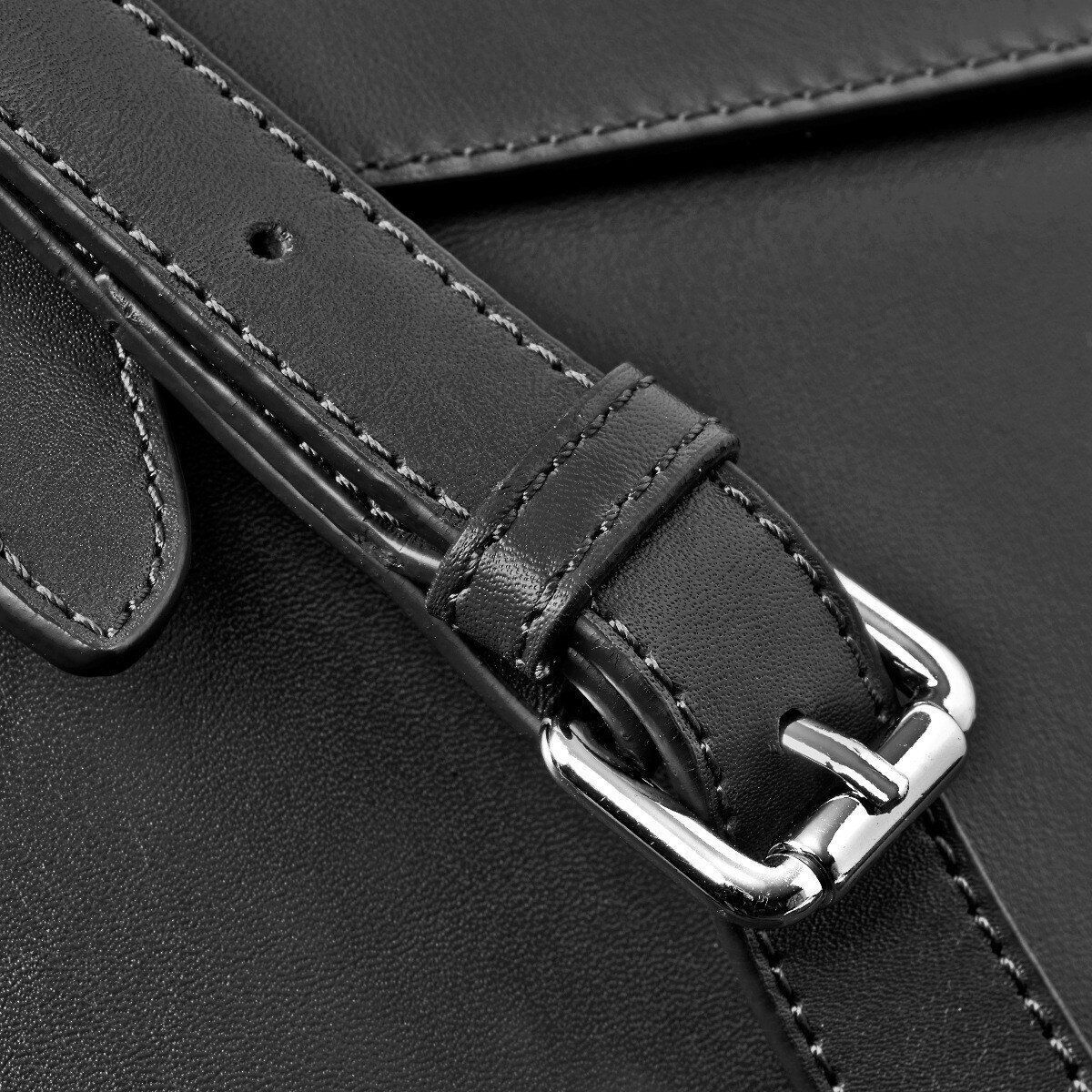 Nahaufnahme einer schwarzen Ledertasche mit silberner Schnalle und gut verarbeiteten Nähten. Ideal für den täglichen Gebrauch und besondere Anlässe.