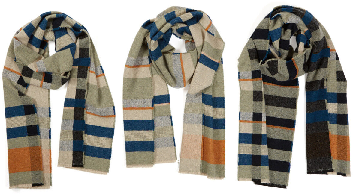 Drei gestreifte Schals aus der Bauhaus Stölzl Kollektion sind auf einem weißen Hintergrund dargestellt. Die Schals zeigen geometrische Muster in verschiedenen Farbvariationen, darunter Kombinationen von Beige, Blau, Grau, Orange, Weiß und Schwarz.