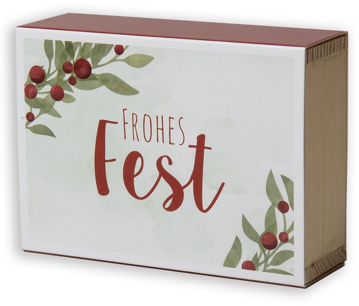 Ein Glückwunschkästchen mit der Aufschrift 'Frohes Fest' und weihnachtlichen Motiven, wie Zweige und Beeren, darauf.