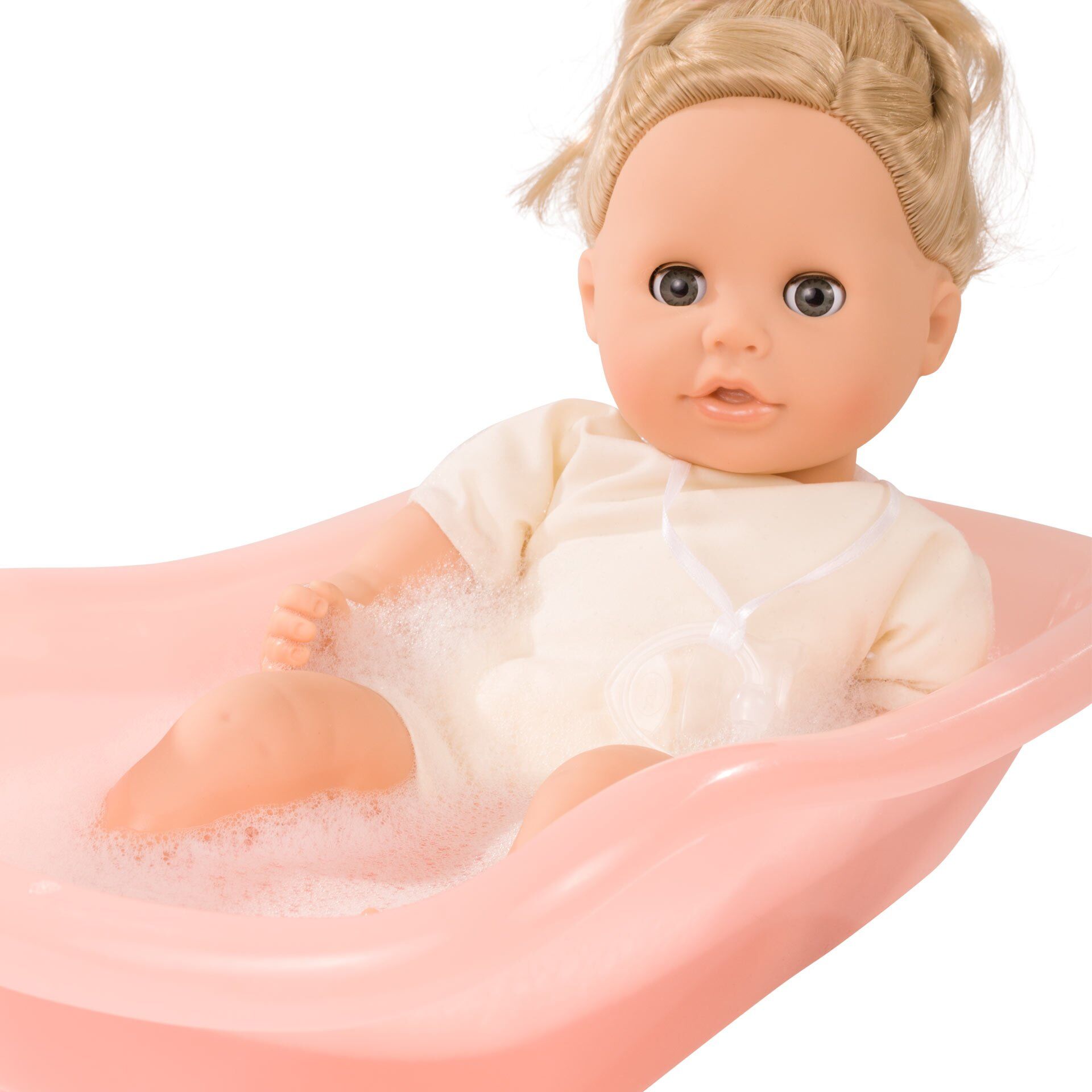 Eine Babypuppe namens »Sleepy Aquini Girl Bliblablume« liegt in einer rosafarbenen Badewanne mit schäumendem Wasser. Die Puppe trägt einen weißen Strampler und ist von Spielschaum umgeben. Das Bild zeigt eine realistische Spielsituation für Kinder.
