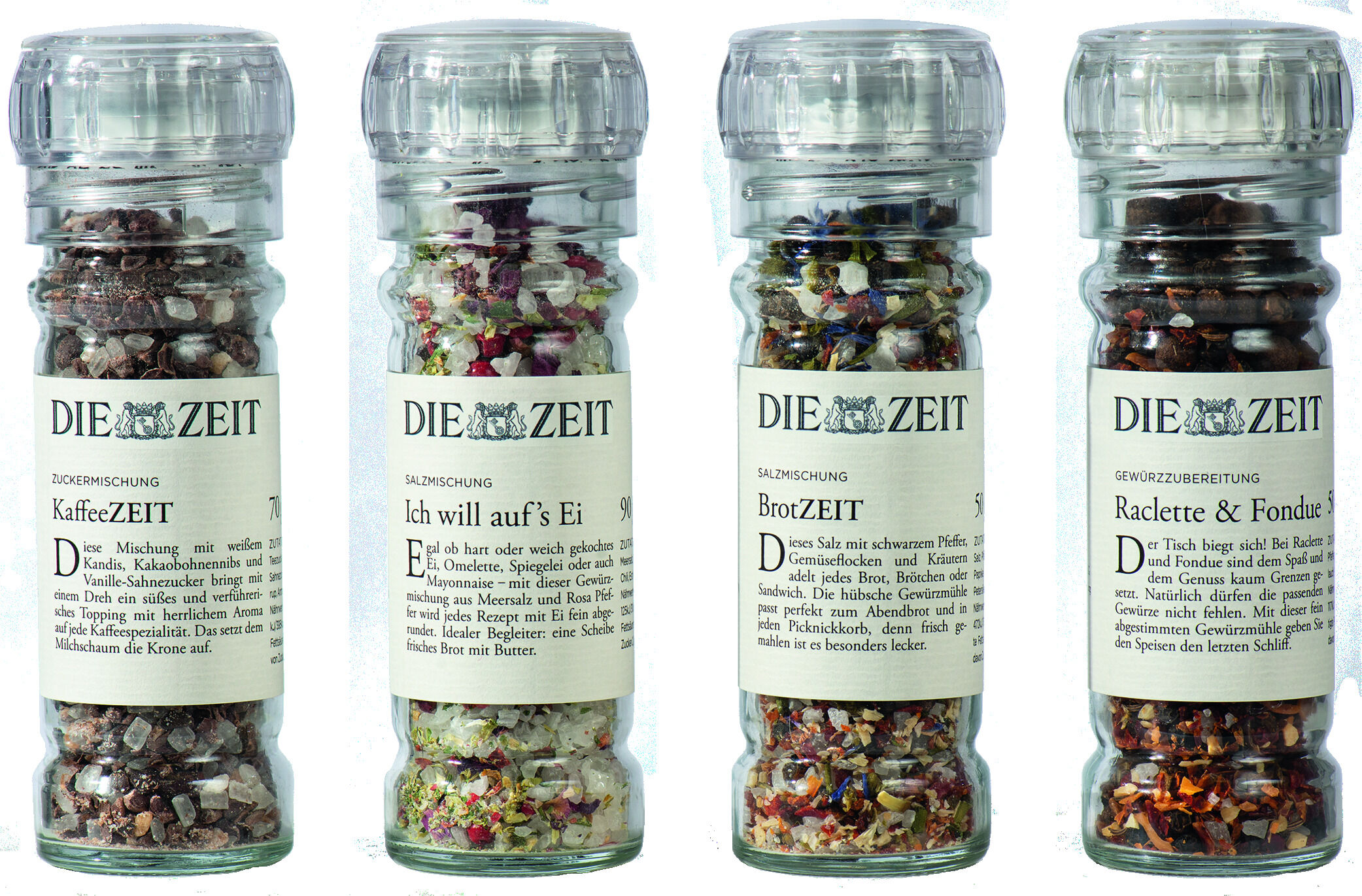 Bild zeigt ein 4er ZEIT Gewürzmühlen-Set mit verschiedenen Gewürzmischungen in transparenten Mühlen. Jede Mühle ist beschriftet und enthält bunte Gewürze.