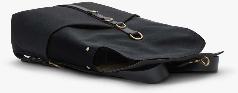 Schwarzer Rucksack von MISMO mit eleganten goldfarbenen Beschlägen und minimalistischen Designelementen, liegend auf einem neutralen Hintergrund.