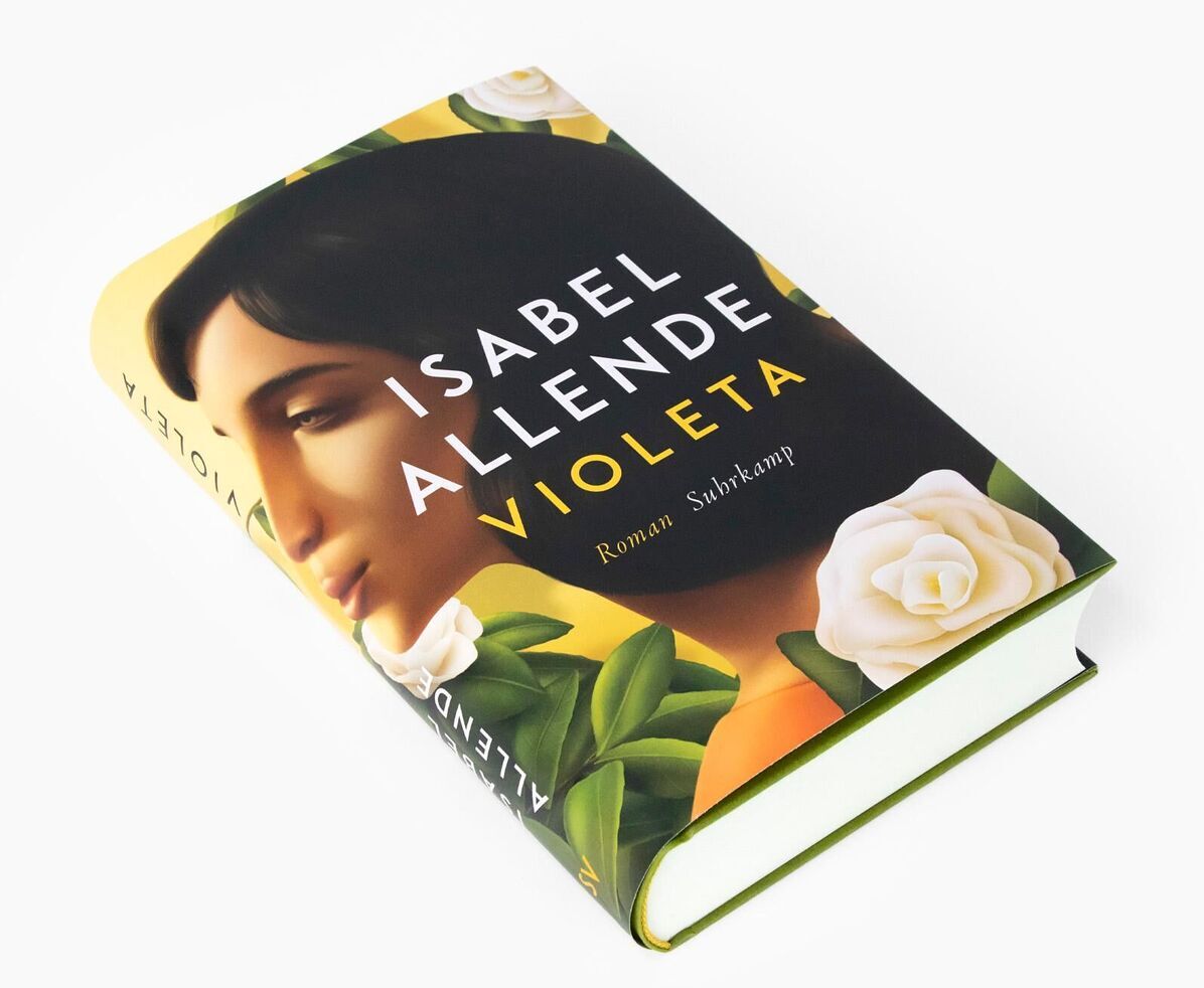 Das Bild zeigt das Buch 'Violeta' von Isabel Allende. Das Cover ist in Gelb-, Weiß- und Grüntönen gehalten und zeigt das Porträt einer Frau, umgeben von Blättern und weißen Rosen.