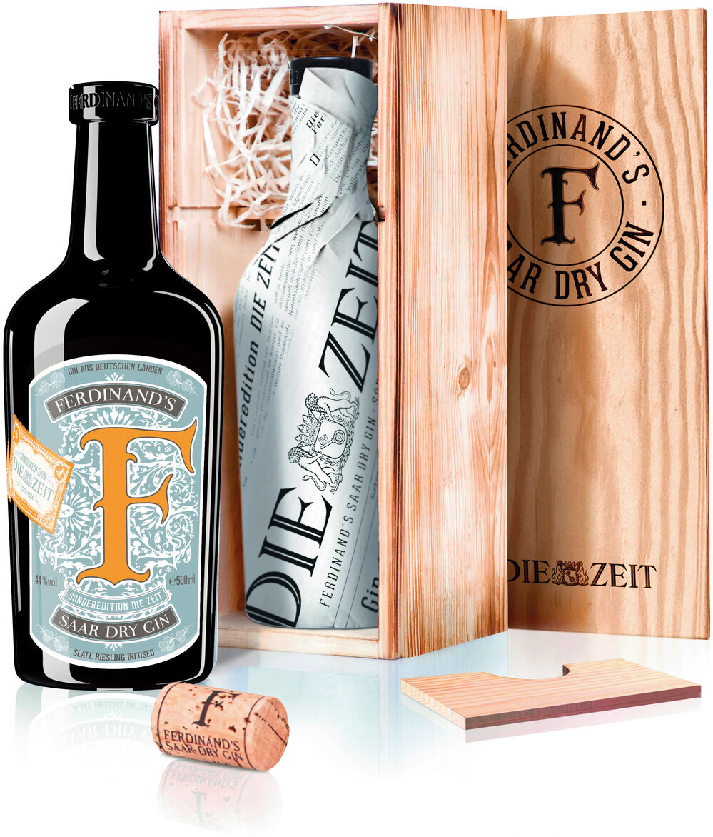 Eine schwarze Flasche Ferdinand's Saar Dry Gin steckt in einer edlen Holzkiste. Die Kiste ist mit weißer Holzwolle gefüllt und enthält einen Korkverschluss. Auf der Flasche befindet sich ein stilvolles Etikett in Blau und Orange. Das Produkt ist als ZEIT-Sonderedition gekennzeichnet.